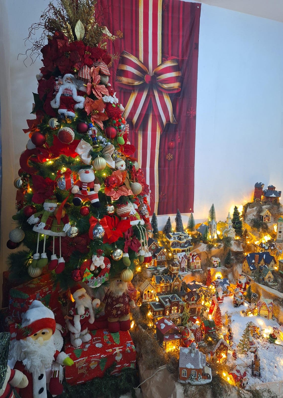Árbol de Navidad clásico junto a una villa nevada con estación de policía e iglesia.